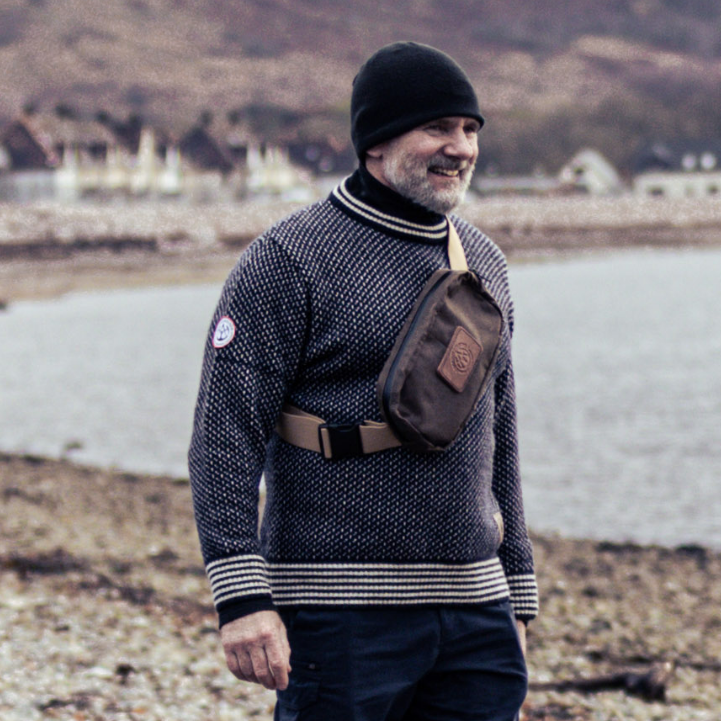 Man wearing Close Hold Bag on his front whilst wearing Gunnerside Sweater on beach