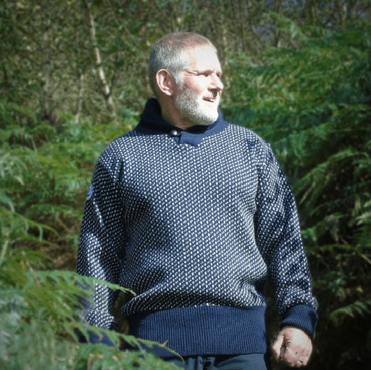 Man standing in ferns wearing Rough bounds Settesda Sweater